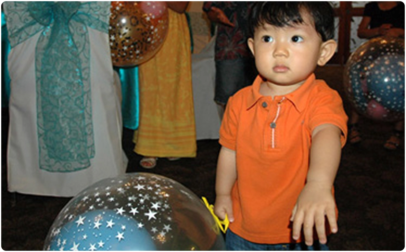 Young child with balloons at a party.