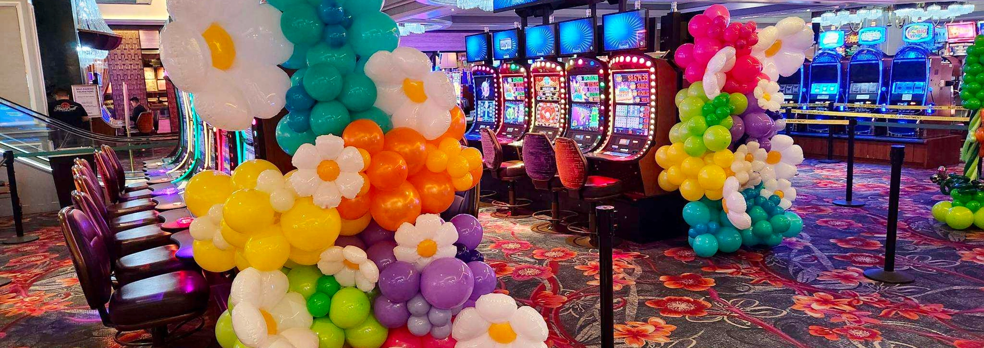 Casino slot machines with colorful balloon decorations.