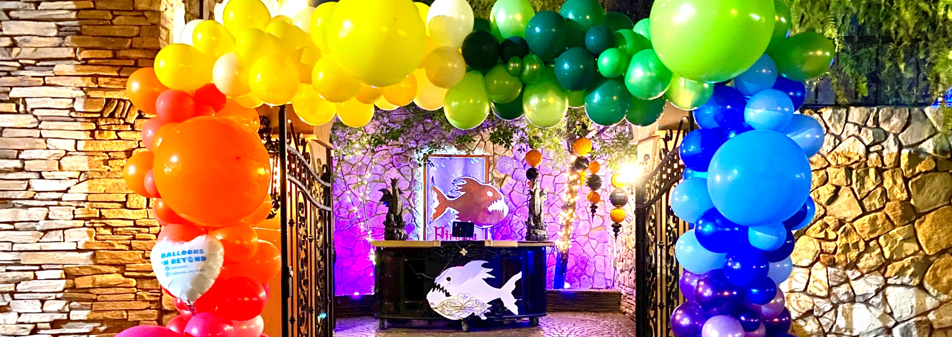 Colorful balloon arch at festive entrance.