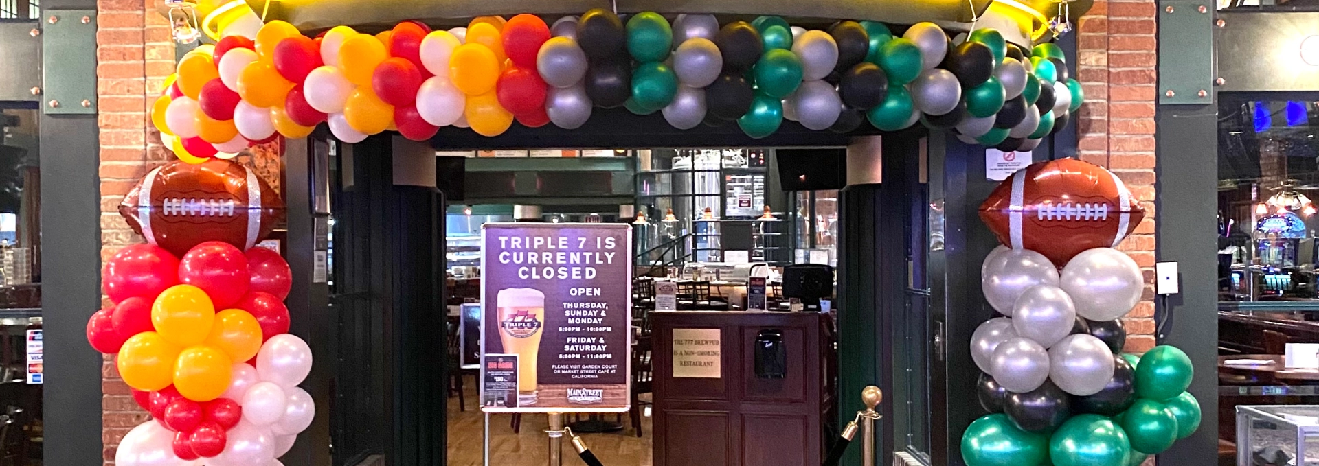 Entrance decorated with colorful balloons, temporarily closed.