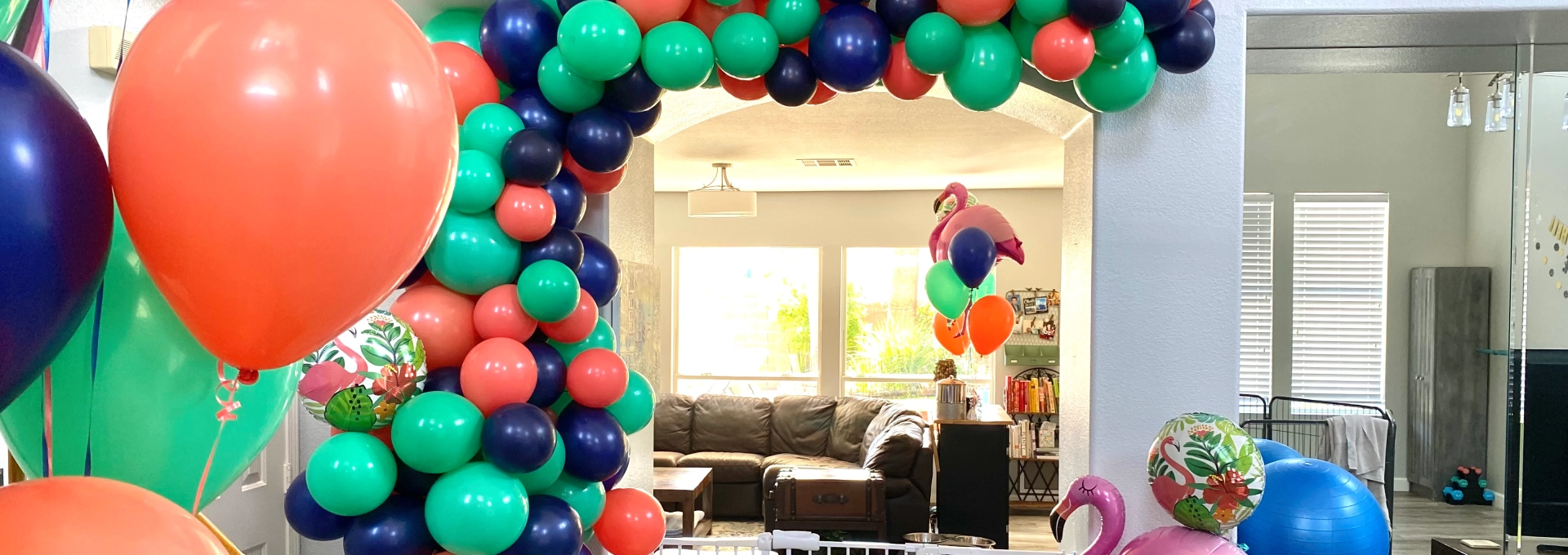 Colorful balloon arch in living room.