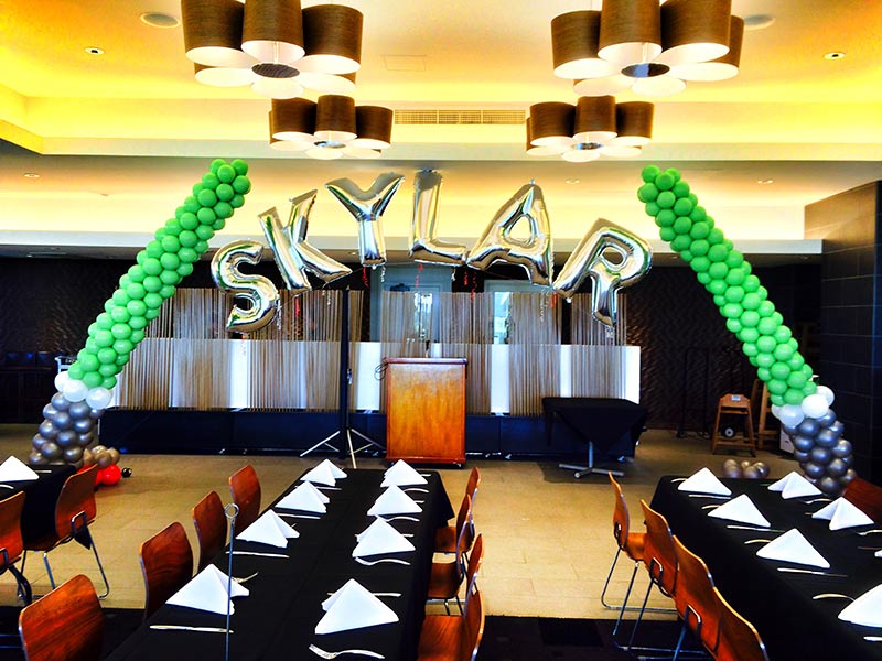 Balloon letters "SKYLAR" in decorated room.