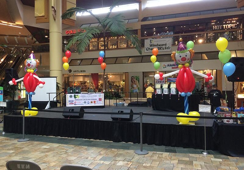 Stage with colorful balloon decorations in mall.