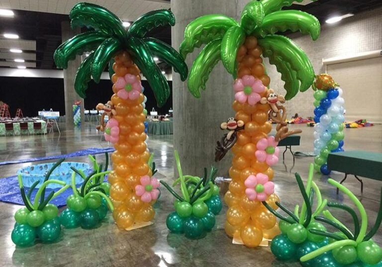 Balloon palm trees with monkey decorations indoors.